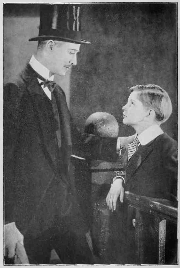 Young boy looking up at gentleman in tophat