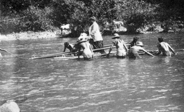 photo of missionary wife standing in wood raft and tai in the water