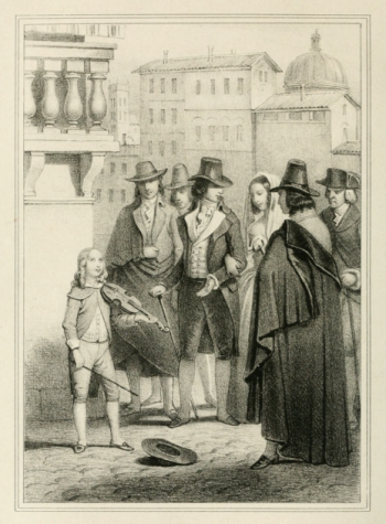 boy with hat on the ground holding a violin in front of several men and women